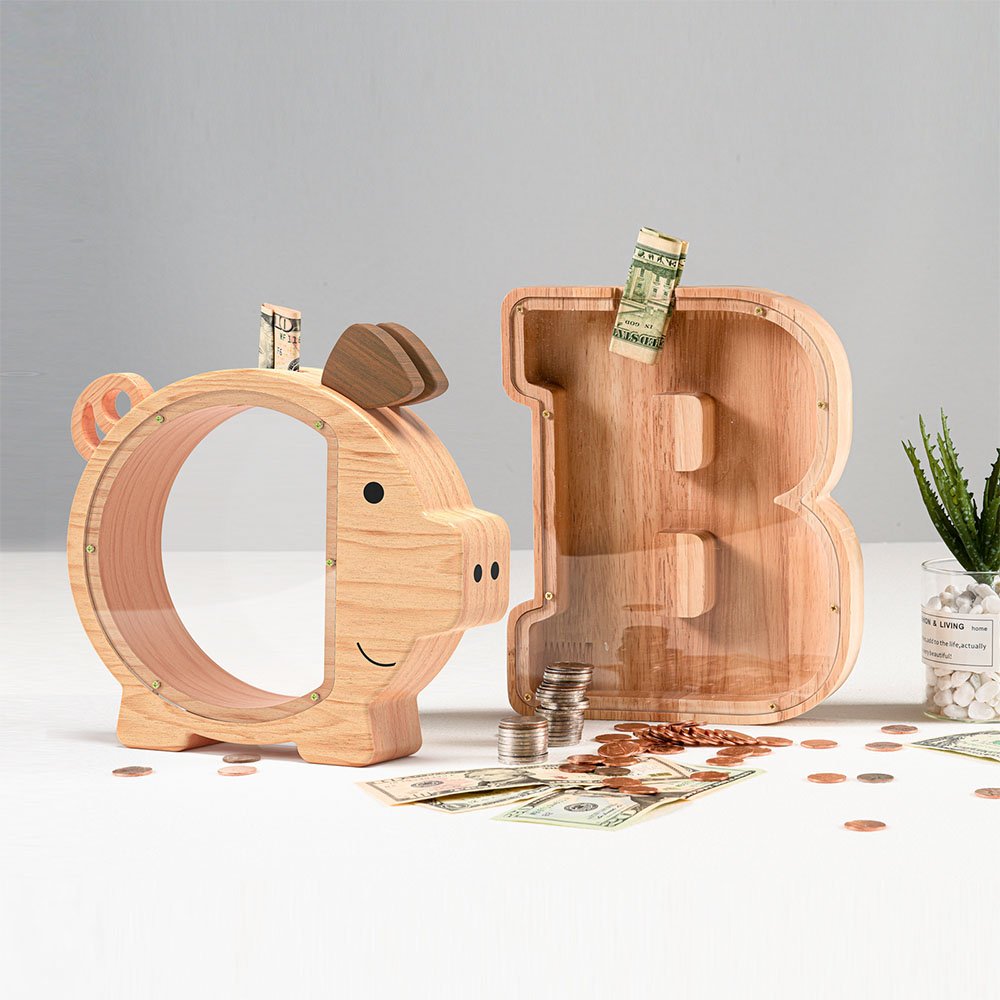 A natural wood pig-shaped money box displayed alongside a letter B alphabet bank. Surrounded by US dollar bills and coins, serving as rustic kids' room decor.