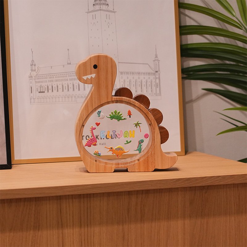 Eco-friendly wooden dinosaur piggy bank displayed on a desk, perfect for boys' room decor and early savings in the UK.