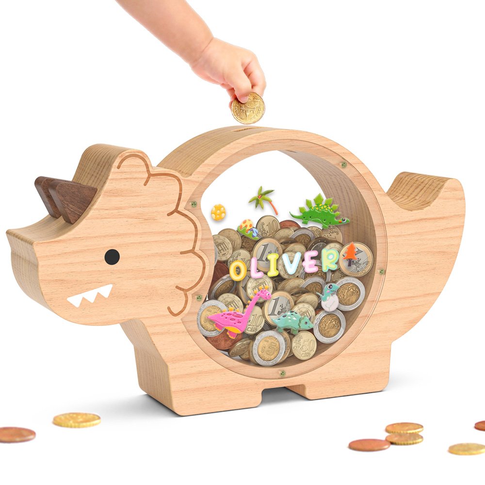 Triceratops wooden piggy bank being filled with coins. A fun, dinosaur-shaped clear savings jar customized to make saving money exciting for kids.