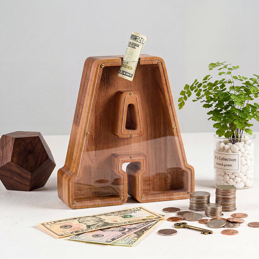 Large 12-inch walnut wooden letter piggy bank with clear acrylic cover, showing coins and multi-currency bills, next to classic piggy bank for comparison, home savings and financial educatio