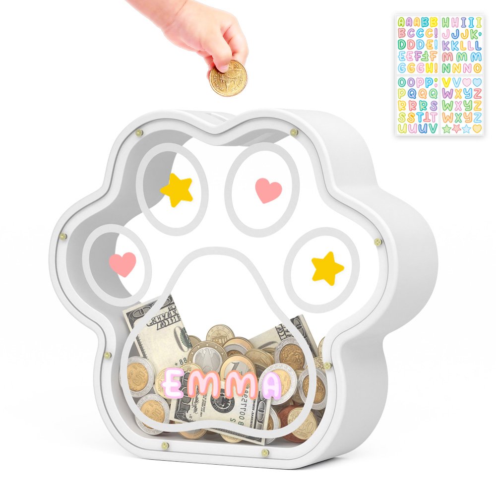 Dropping savings into a white custom name paw coin bank decorated with included alphabet stickers.