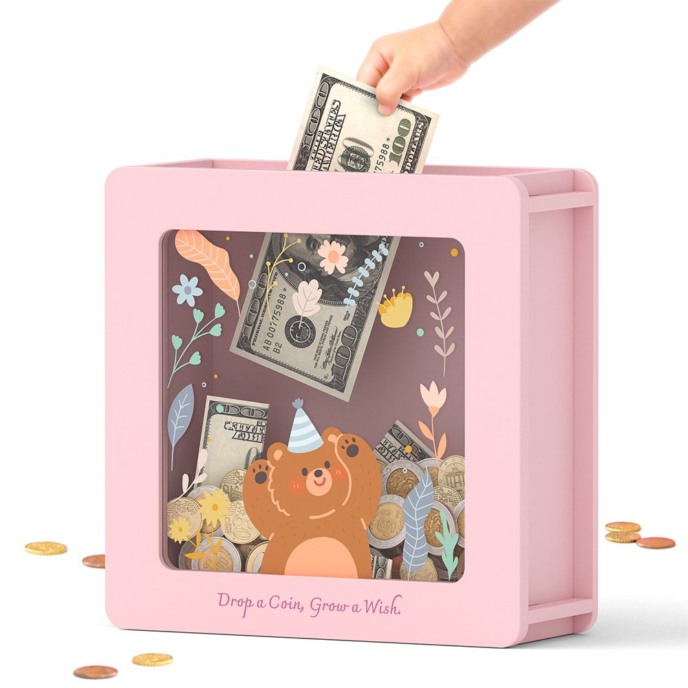 A pink woodland animal money box featuring a little bear with a party hat, perfect as a birthday gift or cute nursery decor for girls.