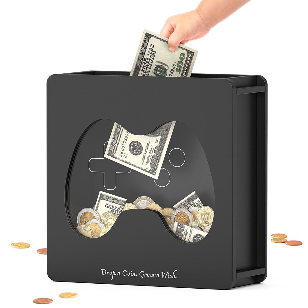 Inserting a folded dollar bill into the top slot of the black video game controller cash bank, perfect for saving allowance money.